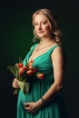 Happy young pregnant woman holding flowers