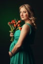 Happy young pregnant woman holding flowers Royalty Free Stock Photo