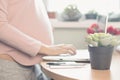 Happy young pregnant woman sitting on bed using technology devices: laptop and cellphone. , close-up Royalty Free Stock Photo