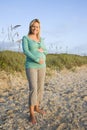 Happy young pregnant woman standing on beach Royalty Free Stock Photo