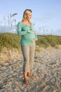 Happy young pregnant woman standing on beach Royalty Free Stock Photo