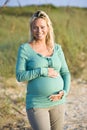 Happy young pregnant woman standing on beach Royalty Free Stock Photo