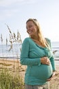 Happy young pregnant woman standing on beach Royalty Free Stock Photo