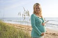 Happy young pregnant woman standing on beach Royalty Free Stock Photo