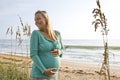 Happy young pregnant woman standing on beach Royalty Free Stock Photo