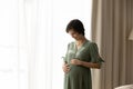 Happy young pregnant woman wearing stylish dress, touching big belly Royalty Free Stock Photo