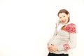 Happy, young pregnant woman in a winter clothing on a white background Royalty Free Stock Photo