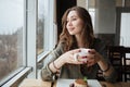 Happy young pretty lady sitting in cafe drinking tea. Royalty Free Stock Photo