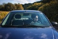 Happy young pretty woman driving a car in country side and smiling. Travel and adventure concept Royalty Free Stock Photo