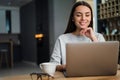 Happy young woman working with laptop and drinking coffee at home Royalty Free Stock Photo