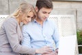 Happy, young professional couple using laptop