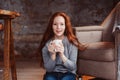 Happy young readhead woman drinking hot coffee or tea at home