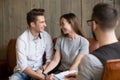 Happy young reconciled couple making up during counseling therap