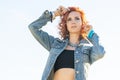 Red-haired woman in fashionable denim jacke