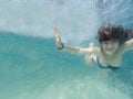 Happy young redhair woman swimming undewater