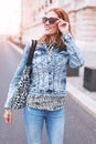 Happy young redhead woman walking on street in city sunset Royalty Free Stock Photo