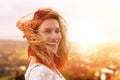 Happy young redhead urban woman looking back in wind Royalty Free Stock Photo