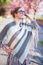 Happy young redhead woman in poncho at spring looking up