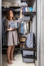 Happy young redhead woman putting clothes and underwear in storage container wardrobe cleaning Royalty Free Stock Photo