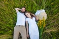 Happy young relaxed couple in love laying down on the grass overhead