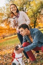 Happy couple walking in autumn park and playing with dogs Royalty Free Stock Photo