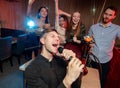 Happy young singers in karaoke bar Royalty Free Stock Photo