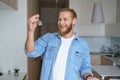 Happy young man renter first time home owner holding key to new apartment Royalty Free Stock Photo