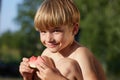 Smiling young boy eating watermelon in outdoor Royalty Free Stock Photo