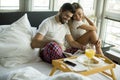 Happy young smiling couple having romantic breakfast in bed Royalty Free Stock Photo