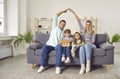 Happy young smiling family making house roof with their hands at home with kids. Royalty Free Stock Photo