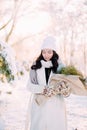 Happy young woman walks in winter forest among trees in sunny day Royalty Free Stock Photo