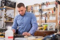 Young male carpenter working wood plank at workshop Royalty Free Stock Photo