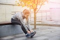 Happy young sporty woman tying shoelaces outdoors Royalty Free Stock Photo