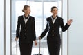 happy young stewardesses at departure area of airport Royalty Free Stock Photo