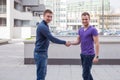 Happy young student giving a handshake to his classmate.