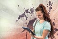 Happy young student woman holding a tablet against white, red and purple splattered background