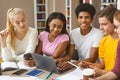 Happy young students working on project at library Royalty Free Stock Photo