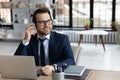 Happy young successful businessman enjoying pleasant music in headphones.