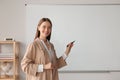 Happy young teacher explaining something at whiteboard in classroom. Space for text Royalty Free Stock Photo