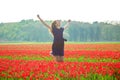 Happy young teen girl jumping up against a spring tulip field. Royalty Free Stock Photo