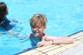 Happy young teenage boy relaxing on the side of swimming pool during summer vacation Royalty Free Stock Photo