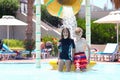 Happy kids having fun in the resort pool doing ice bucket challenge during summer vacation Royalty Free Stock Photo