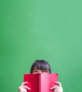 Happy young teenager girl holding red book cover face with think Royalty Free Stock Photo