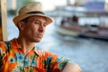 Happy young tourist man thinking while riding boat on the river