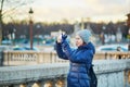 Happy young tourist taking a photo with her mobile phone in Paris Royalty Free Stock Photo