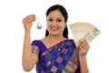 Happy young traditional woman holding Indian currency and house Royalty Free Stock Photo