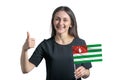 Happy young white woman holding flag of Abkhazia and shows the class by hand isolated on a white background