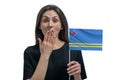 Happy young white woman holding flag of Aruba and covers her mouth with her hand isolated on a white background