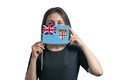 Happy young white woman holding flag Fiji flag and covers her face with it on a white background