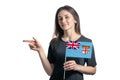 Happy young white woman holding flag Fiji and points to the left isolated on a white background